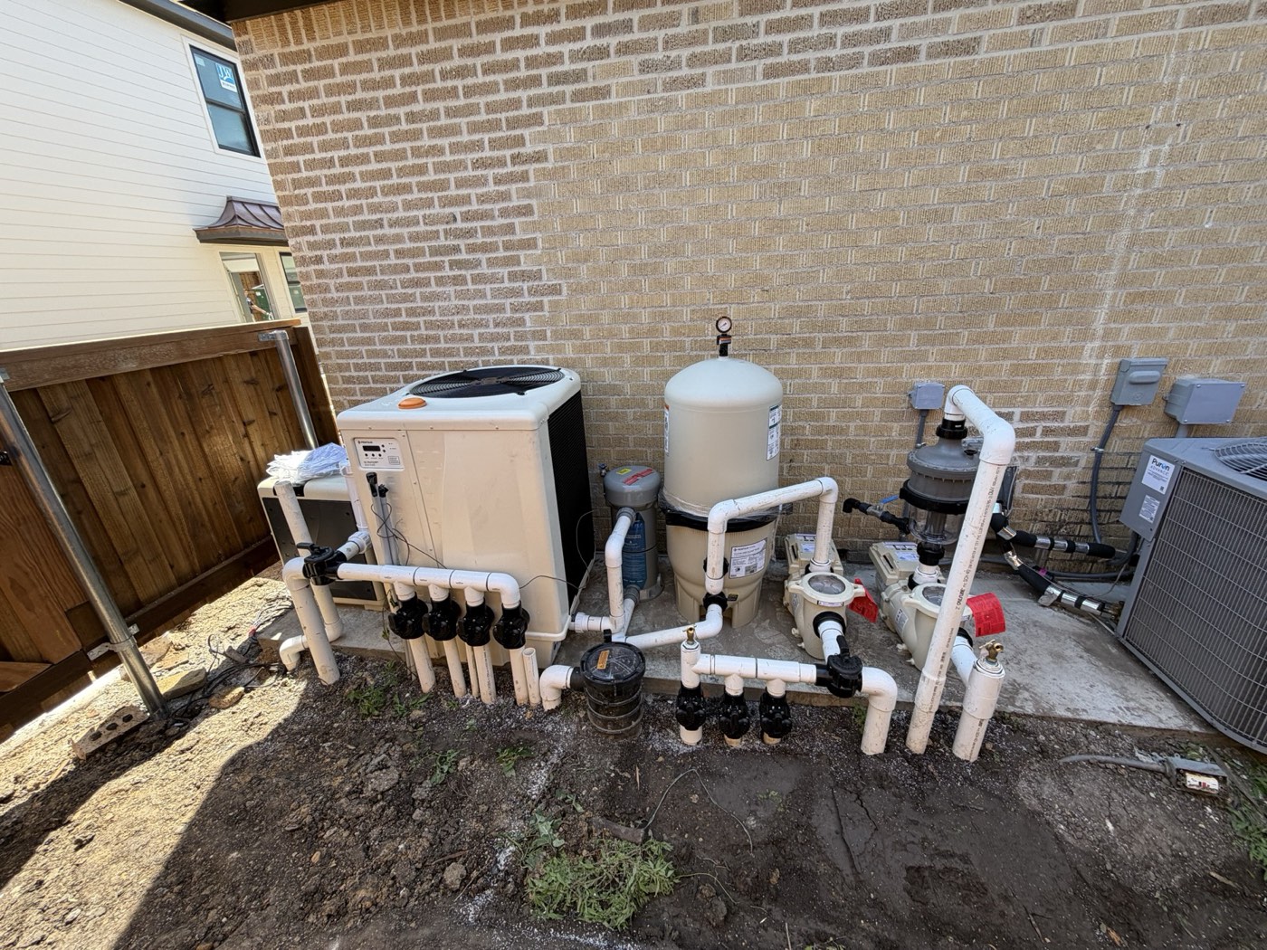 Pool equipment pad with heat pump, filter and pumps