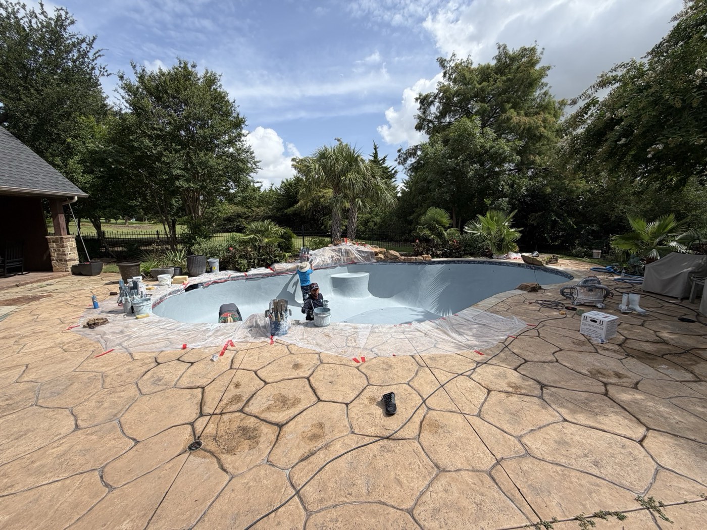 Real Pools crew resurfacing a drained pool with fresh plaster